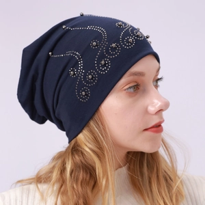 Detail of navy cotton beanie featuring decorative rhinestone and pearl floral patterns