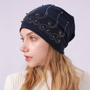 Detail of navy blue cotton beanie with silver studs wave pattern on a female model