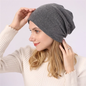 Detailed view of gray slouchy beanie featuring vertical rows of shimmering rhinestones