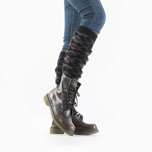 Detalle de calentadores de punto con diseño de rombos marrones y negros sobre botas de cuero