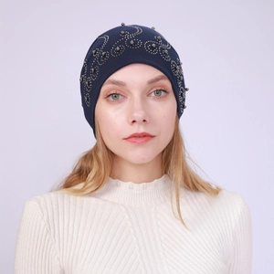 Detail of dark blue cotton beanie showing elegant silver beadwork and rhinestone patterns