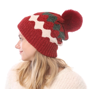 Detail der weichen Chenille-Strickmütze mit Bommel und Winterwellenmuster an einem Modell