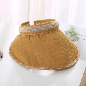 Close-up of yellow sun visor featuring ribbed fabric, silver embroidery and white dots