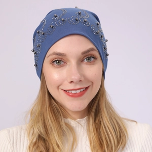 Detail of blue cotton beanie featuring elegant spiral silver bead and rhinestone patterns