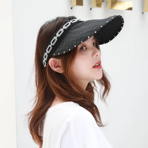 Detail of black visor hat with white chain embroidery and polka dots on wide brim