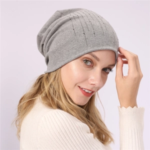 Detail of grey slouchy beanie with vertical rhinestone accents and soft knit texture