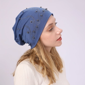 Detail of blue cotton beanie featuring elegant pearl and rhinestone scroll patterns