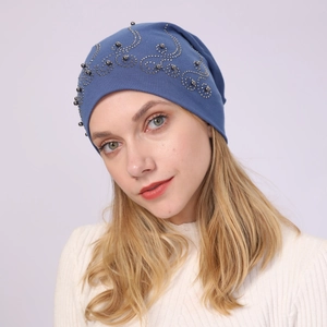 Close-up of navy cotton beanie with elegant pearl and rhinestone scroll pattern detail