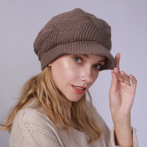 Detail of dark brown cable knit newsboy hat with textured wool blend and stylish short brim