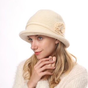 Detail of soft plush knitted winter hat for women with elegant floral decoration
