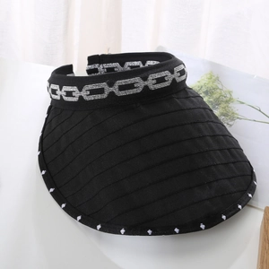 Close-up of black sun visor hat with silver chain pattern and dotted edge detail