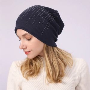 Detail of navy blue slouchy beanie featuring vertical silver rhinestone stripes and knit fabric