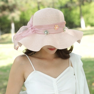 Cappello di paglia rosa a tesa larga ondulata con fiocco floreale e perle da donna