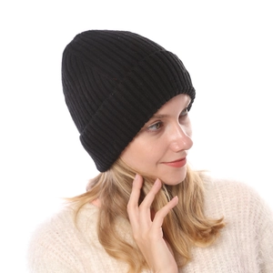 Detailed view of the black ribbed knit texture and wide folded brim on a warm beanie