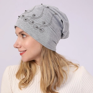Detail view of light grey slouchy beanie featuring elegant silver rhinestone wave pattern