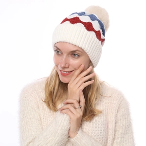 Detailaufnahme der weichen Strickmütze mit Wellenmuster und Kunstfell-Bommel für Damen