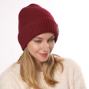 Close-up of deep burgundy ribbed knit beanie showing soft wool texture and folded cuff