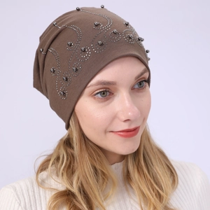 Detailed view of brown cotton beanie featuring intricate beadwork and rhinestone patterns
