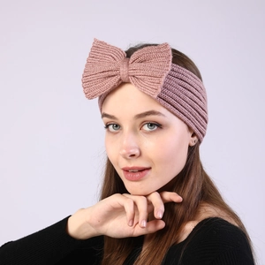 Detail of soft pink knitted bow headband showing the ribbed texture and fine stitching