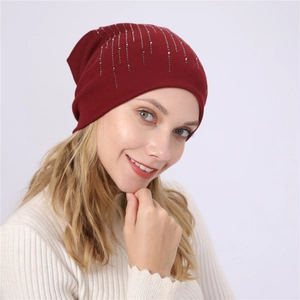 Detail view of burgundy cotton slouchy beanie with vertical rhinestone fringe patterns