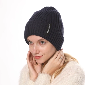 Detailed close-up of dark blue ribbed knit beanie with white Breakout letter logo tag