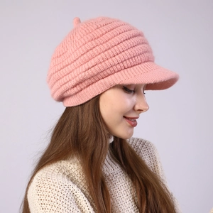 Close-up of thick knitted pink beret with short brim and soft winter texture