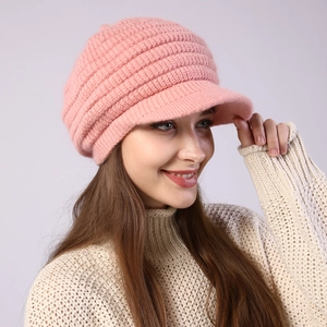 Detail of light pink knitted visor beanie showing thick ribbed wool texture and brim