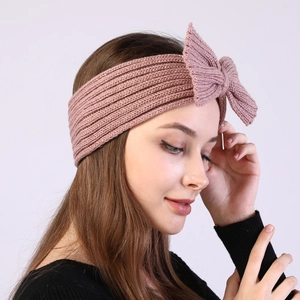Close-up of pink knitted headband with bow decoration showing soft ribbed texture