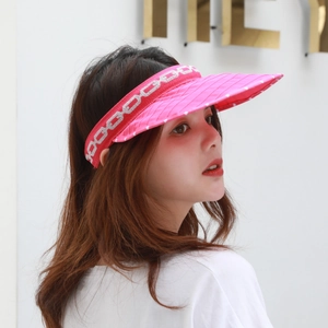 Detail of rose pink sun visor with white dots and silver chain pattern embroidery