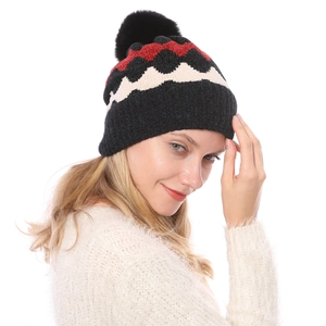 Detail von weichem Wellenmuster und flauschigem Bommel an dicker Winter-Strickmütze für Damen