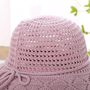 Detail of the crochet hollow knit pattern and decorative bow on the light pink sun hat