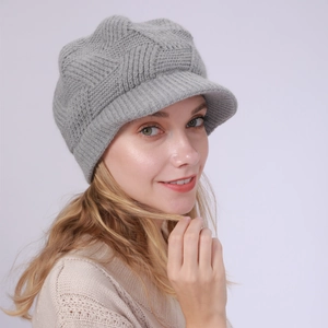 Detail of grey knitted peak cap showing textured diamond pattern and warm winter fleece