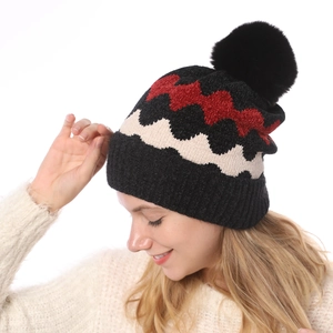 Detailansicht der weichen Chenille-Strickmütze mit Wellenmuster und Kunstpelz-Bommel