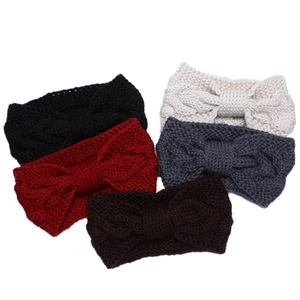 Detail of five thick knitted headbands with decorative bows in various winter colors