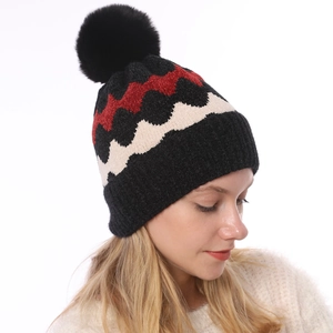 Detail der weich gestrickten Beanie mit Wellenmuster und Plüsch-Pompon für den Winter