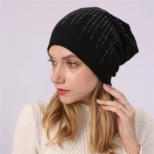 Close-up of black cotton beanie featuring vertical silver rhinestone patterns on casual knit
