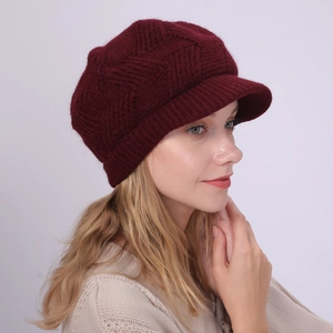 Close-up of deep wine red knit baker boy hat with 3D geometric weave texture detail