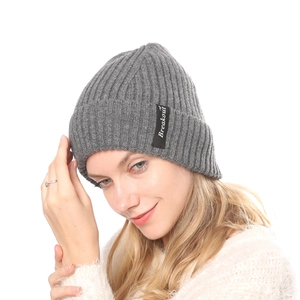 Close-up of grey ribbed knit beanie with Breakout label worn by a female model