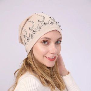 Detail of beige slouchy beanie with silver rhinestones and pearls in a wave pattern