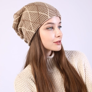 Close-up detail of khaki and beige knit beanie with geometric diamond textures