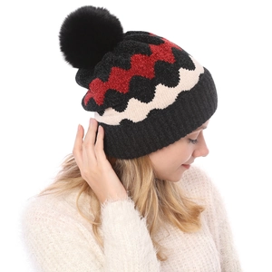 Detail der Winterstrickmütze mit schwarzem Bommel und bunten Wellenmustern
