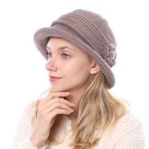 Detail of a thick knitted winter bucket hat for women with a side flower decoration