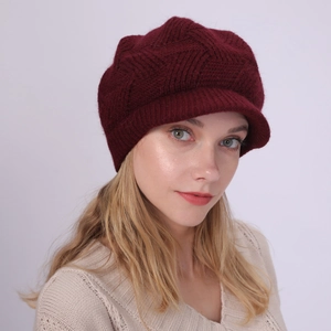 Close-up of wine red knit newsboy hat showing thick textured weave and short brim