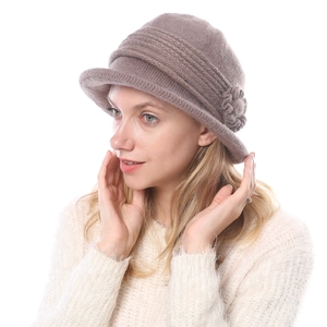 Detail of warm khaki knit bucket hat with floral accent and soft wool texture