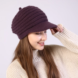 Detail view of purple striped knit newsboy cap with pom-pom and fleece lining