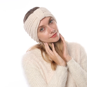 Dettaglio della fascia in ciniglia beige lavorata a maglia indossata da una modella