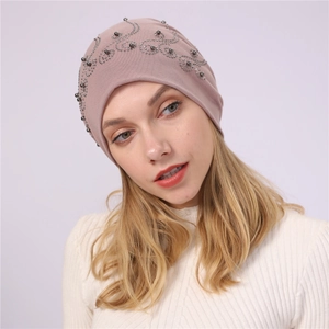 Detailed view of the pearlescent rhinestone scroll pattern on the soft cotton beanies