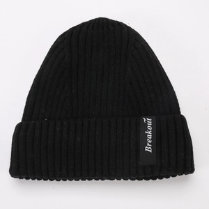 Close-up of black ribbed knit beanie featuring a white Breakout label and thick folded cuff