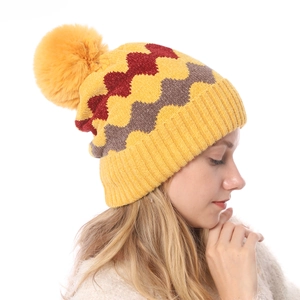 Detaillierte Nahaufnahme der bunten Strickmütze mit Wellenmuster und weichem Bommel