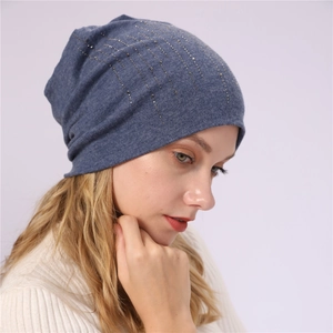 Detail of dark blue slouchy beanie with rhinestone embellishments worn by a model
